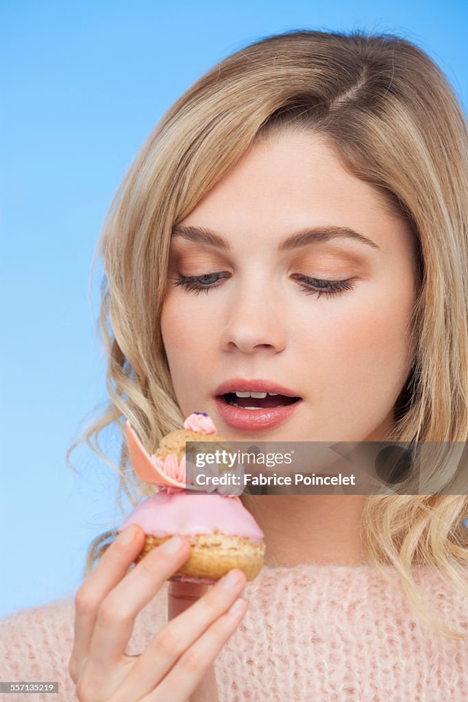 Close-up of a beautiful woman eating a french strawberry religieuse