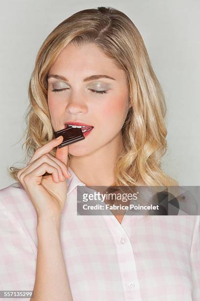 beautiful woman eating chocolate - woman chocolate stock pictures, royalty-free photos & images