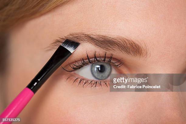 beautiful woman brushing eyebrow - eyebrow stock-fotos und bilder