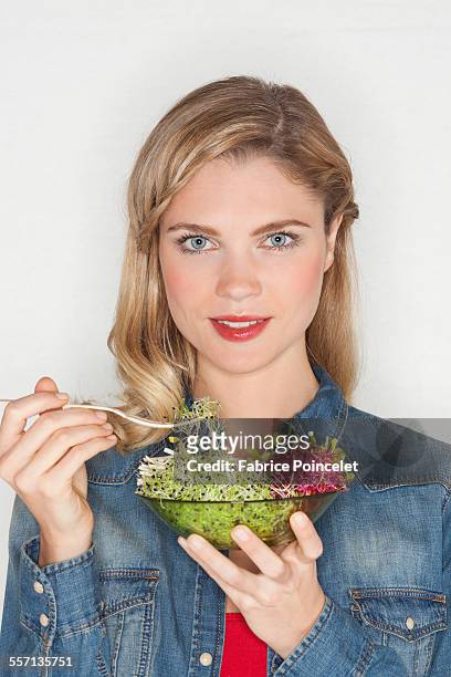 portrait of a beautiful woman eating bean sprout - sojabohnensprosse stock-fotos und bilder