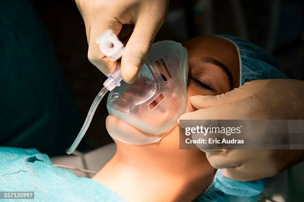 anesthetist holding oxygen mask over patients mouth in an operating room - anesthesiologist imagens e fotografias de stock