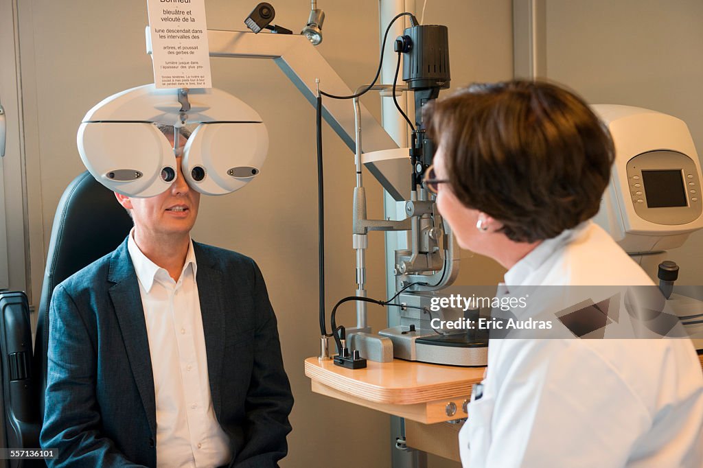 Female optometrist examining mans eyes
