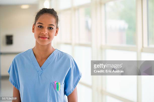portrait of a female nurse smiling - female nurse stock-fotos und bilder