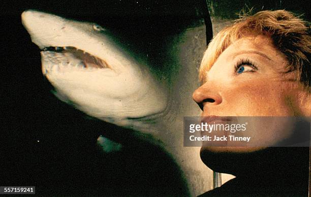 Close-up portrait of Kathleen Hacker as she looks into a tank as a shark swims past, Baltimore, Maryland, 1980s.