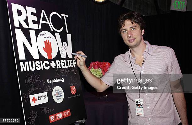 Actor Zach Braff signs a poster backstage at the "ReAct Now: Music & Relief" benefit concert at Paramount Studios on September 10, 2005 in Hollywood,...