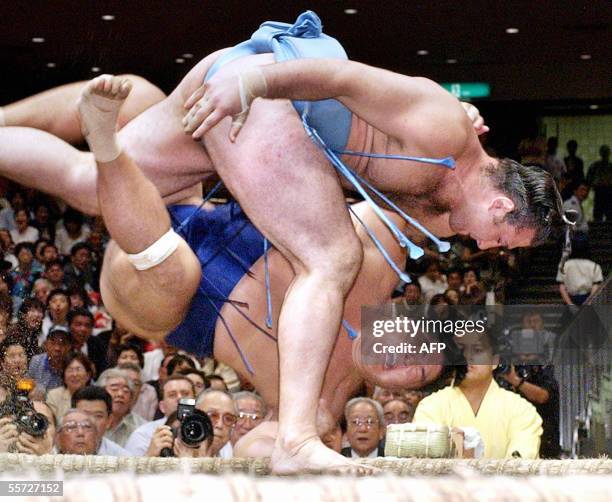 Bulgarian sekiwake ranked sumo wrestler Kotooshu throws Tomanoshima to the ground at a 10th day bout of the Autumn Grand Sumo Tournament in Toyko 20...