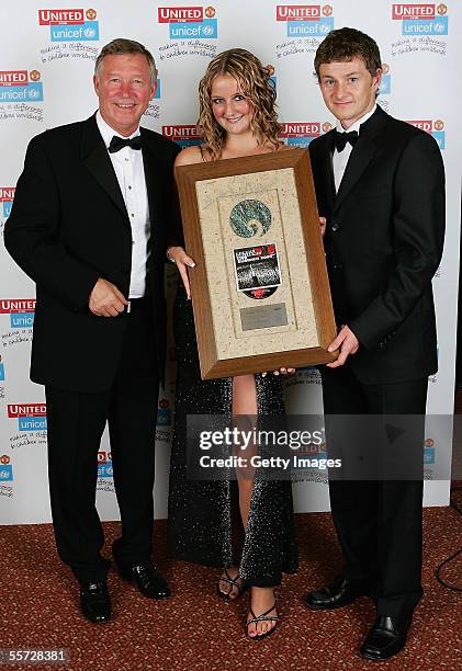 Sir Alex Ferguson and Ole Gunnar Solskjaer of Manchester United present an auction winner with her prize at the annual United for Unicef charity...