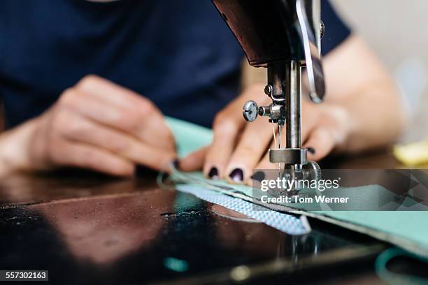 young fashion designer working on sewing machine - stitch stock pictures, royalty-free photos & images