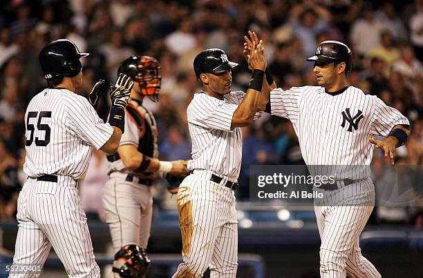 Jorge Posada of the New York Yankees celebrates his three run home run in the first inning with Gary Sheffield and Hideki Matsui against John Maine...
