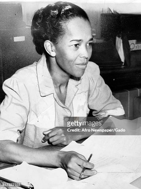 Portrait of American Civil Rights activist Ella Baker , the NAACP Hatfield representative, as she sits behind a desk covered with paperwork,...