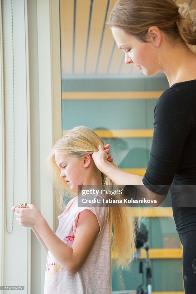 Mother combs her daughter's hair