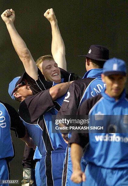 In this picture taken 31 January 2002, England cricketer Andrew Flintoff raises his arms as he celebrates a dismissal with his teammates during the...