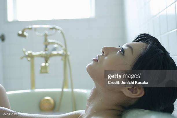 close-up of a young woman in bathtub - japanese women bath stock pictures, royalty-free photos & images
