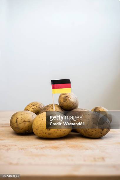 row potatoes and small german little flag on wood - german culture stock-fotos und bilder