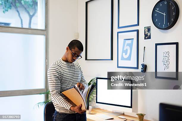 young creative man with files in his home office - picture frame desk stock pictures, royalty-free photos & images