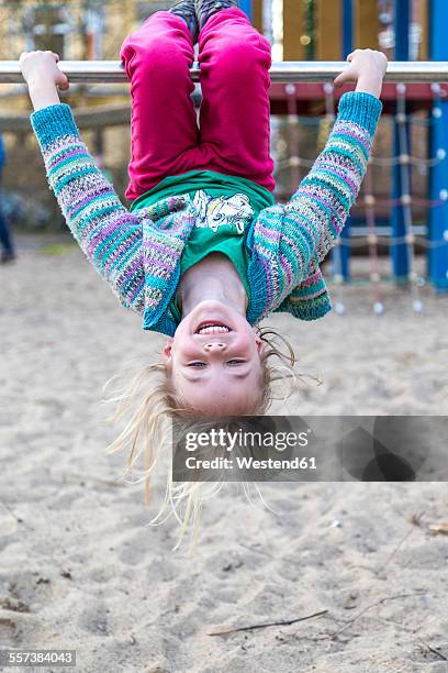 germany, kiel, little girl hanging on bar upside down - barra horizontal imagens e fotografias de stock