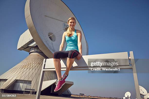 germany, raisting, young female jogger having a rest at ground station - raisting stock-fotos und bilder