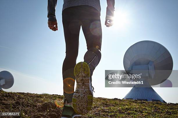 germany, raisting, back view of young jogger at ground station - raisting stock-fotos und bilder