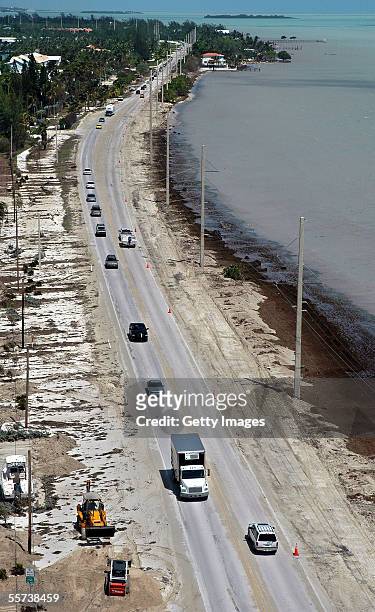 In this handount photo provided by the Florida Keys News Bureau, front-end loaders work to clear sand and seaweed from the Overseas Highway a day...