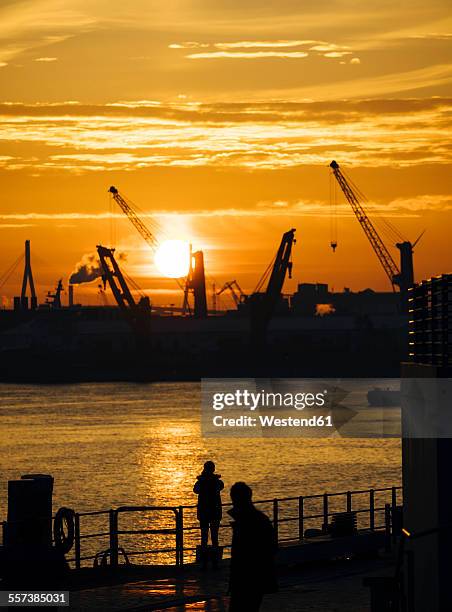 germany, hamburg, silhouettes of harbour cranes at sunset, koehlbrand bridge in the background - köhlbrandbrücke stock pictures, royalty-free photos & images