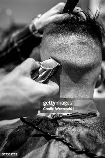 hairdresser shaving young man's back of the head in a barbershop - shaved-buzz-cut-back-of-head photos et images de collection