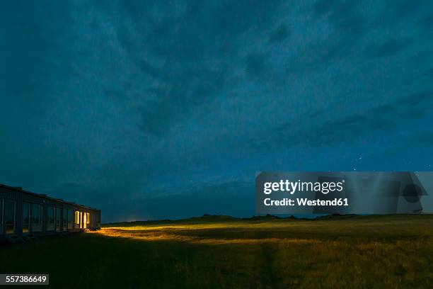 iceland, view to lighted motel by night - motel stock-fotos und bilder