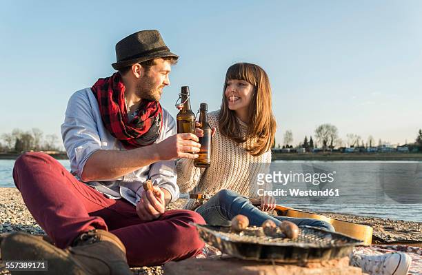 couple at the riverside - bierwurst stock-fotos und bilder
