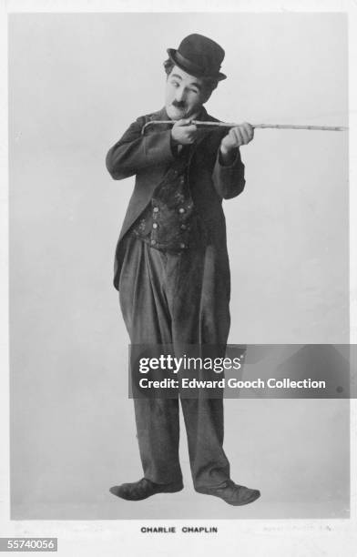 British comic actor and film director Charlie Chaplin takes aim with his walking stick in character as the Little Tramp, circa 1925.