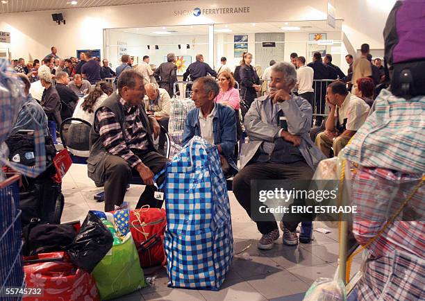 People wait for the departure of a ferry bound for Tunisia, late 22 September 2005 in Toulon harbour on strike, southern France. Workers for the...