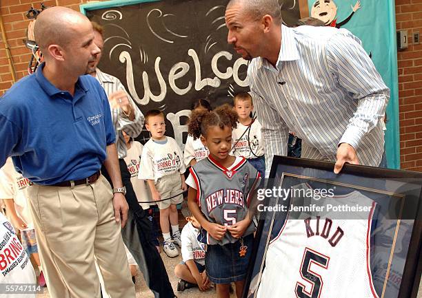 Jason Kidd presents a signed jersey to Principal Michael Cullen after attending class with first grader Angelique Allen at Tamaques Elementary School...