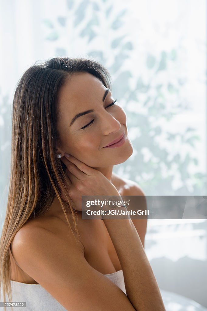 Caucasian woman rubbing her neck on massage table