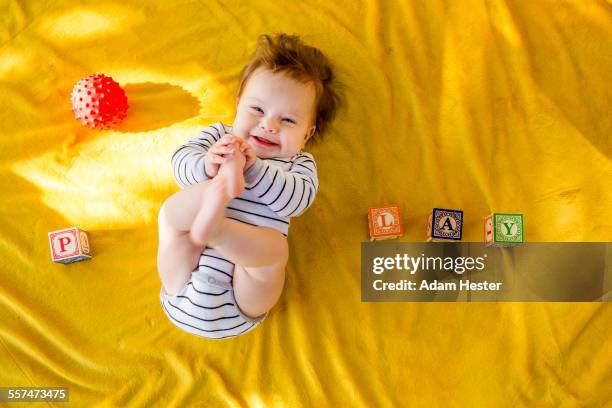 caucasian baby girl playing with blocks on bed - letter p foto e immagini stock