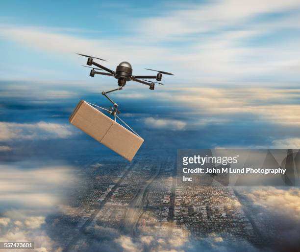 aerial view of drone carrying package in cloudy sky - skybox stockfoto's en -beelden