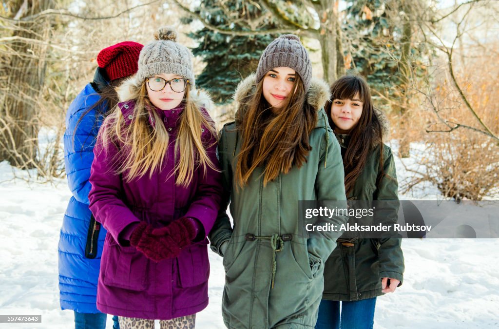Caucasian girls standing in snowy field