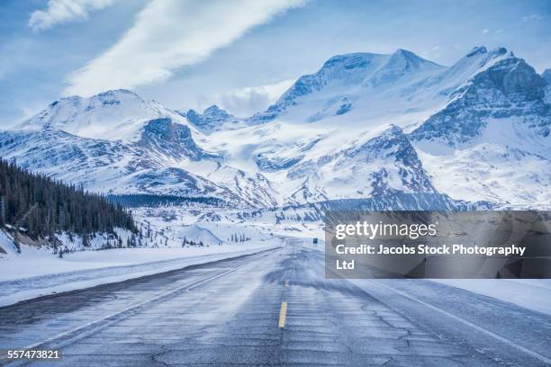 snowy mountains over field and icy roads - neige épaisse photos et images de collection