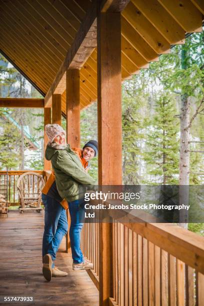 caucasian couple playing on log cabin porch - leaning tree stock pictures, royalty-free photos & images