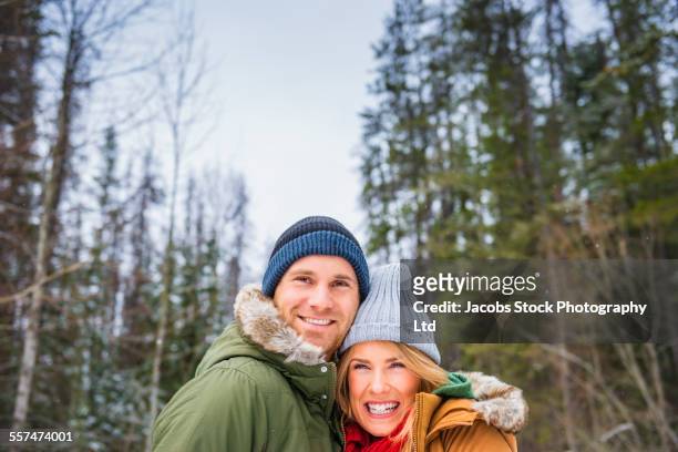 caucasian couple hugging in winter forest - parka cappotto invernale foto e immagini stock