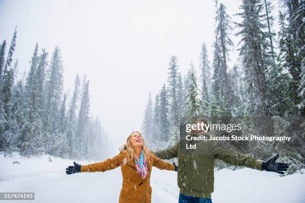 caucasian couple catching snowflakes on tongues - lake louise stock pictures, royalty-free photos & images