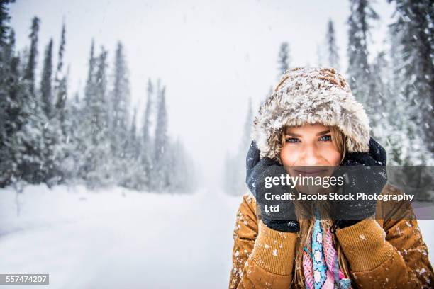 caucasian woman wearing fur parka hood in snow - fur glove stock pictures, royalty-free photos & images