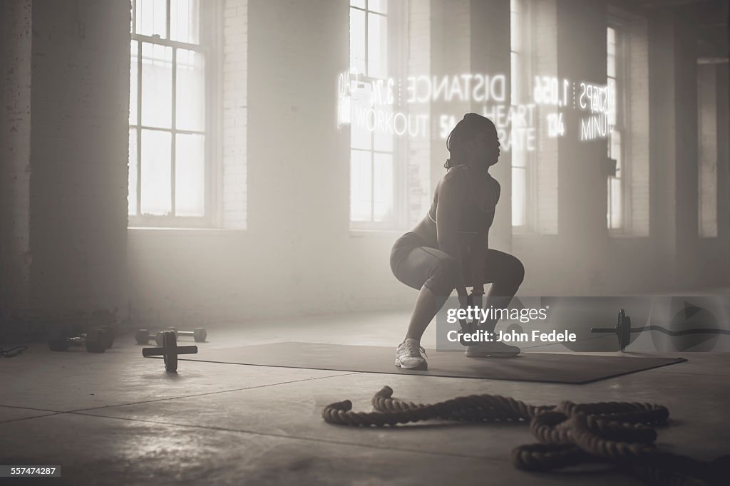 Virtual words circling Black athlete lifting kettlebell