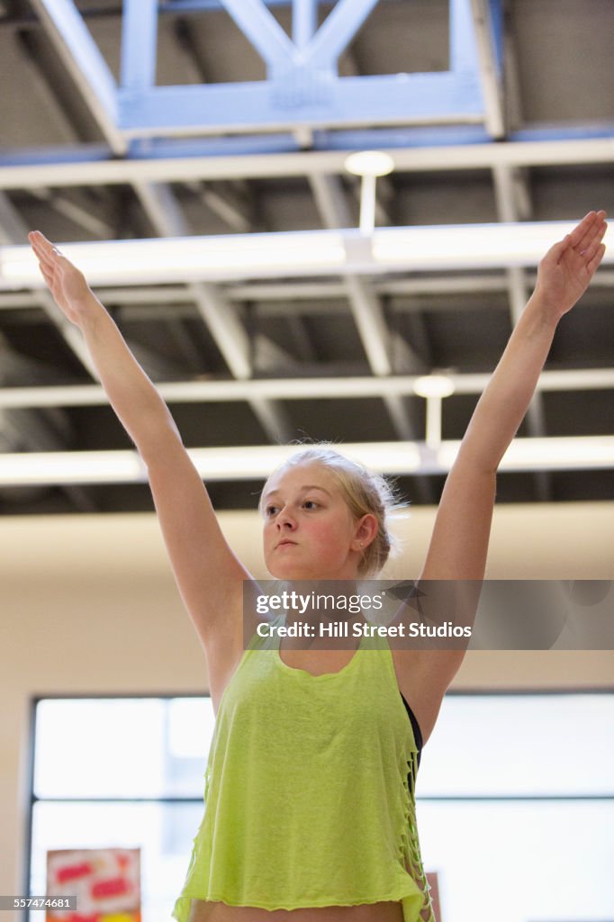 Dancer practicing with arms raised in rehearsal