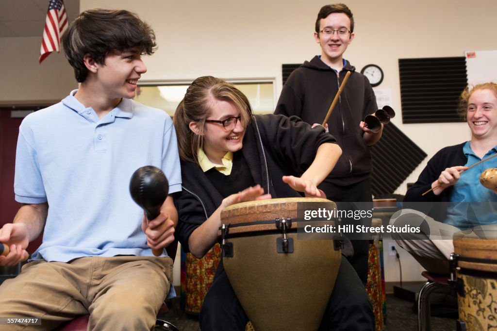 Students playing bongo drums in high school band class