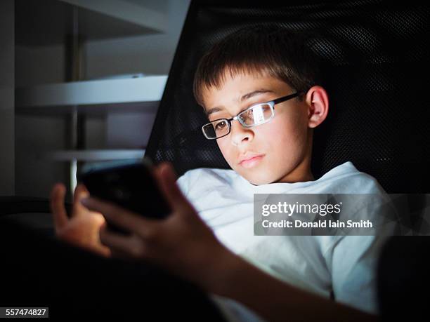 mixed race boy texting on cell phone at night - palmerston north nz bildbanksfoton och bilder