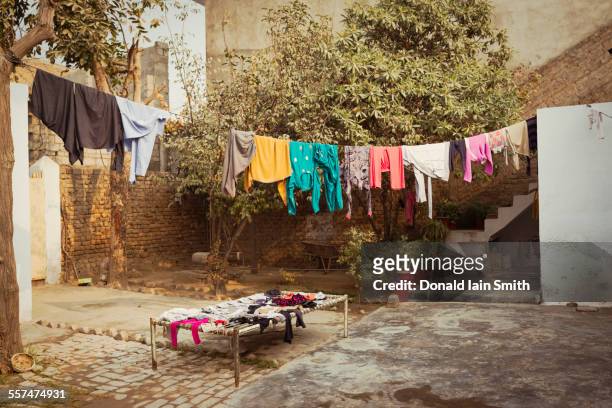 laundry drying on clothesline in backyard - courtyard stock-fotos und bilder