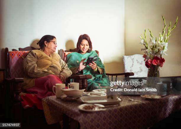 mother and daughter using cell phone at dinner table - indian family dinner table stock pictures, royalty-free photos & images