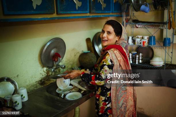 woman washing dishes in kitchen - pakistan women stock pictures, royalty-free photos & images