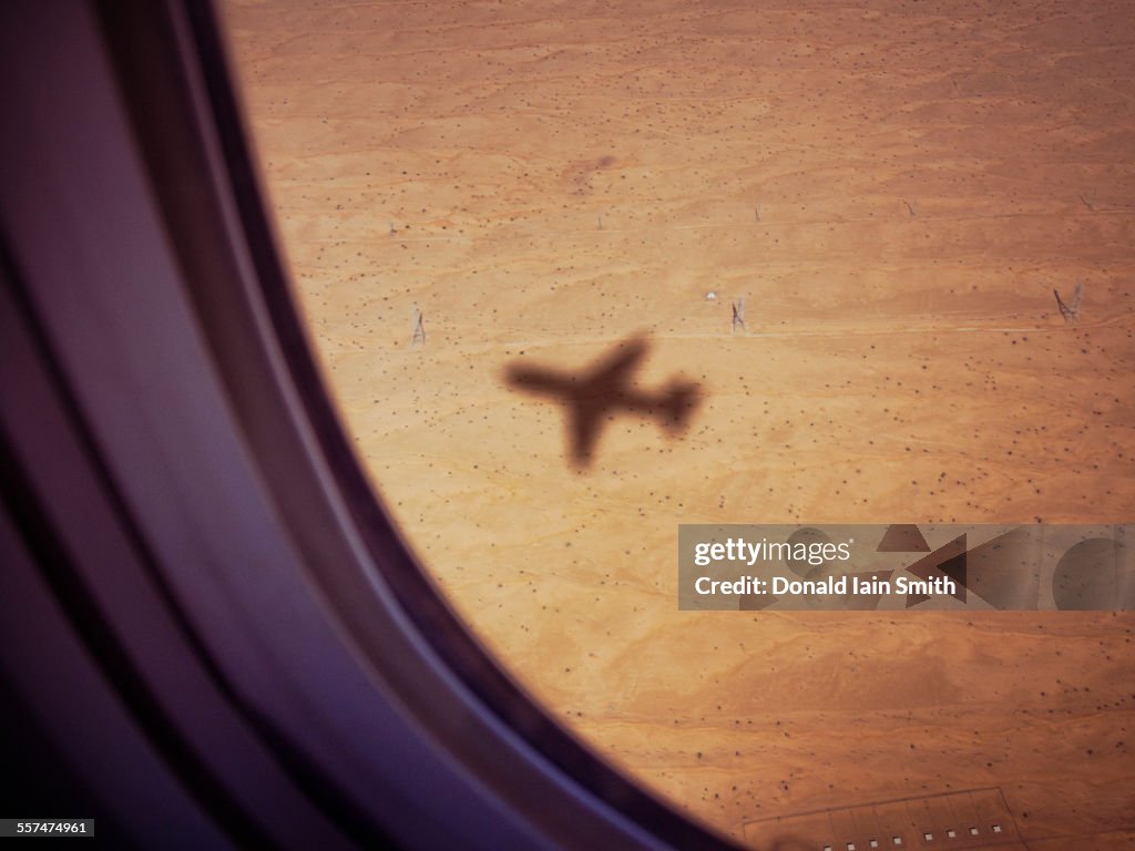 Shadow of airplane on desert ground