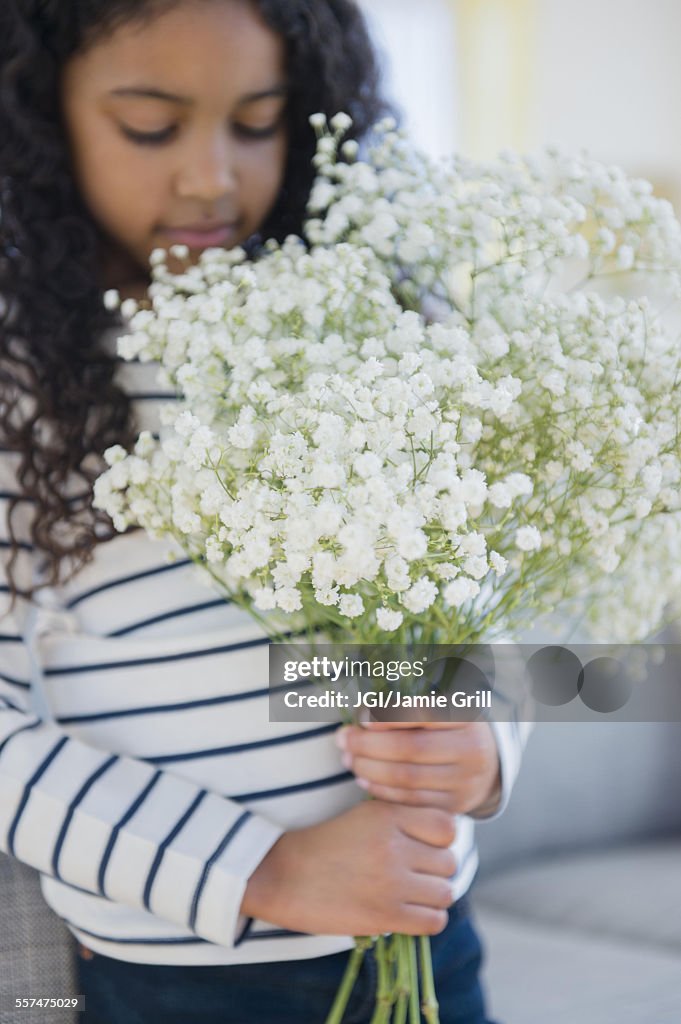 Mixed race girl holding bouquet of flowers