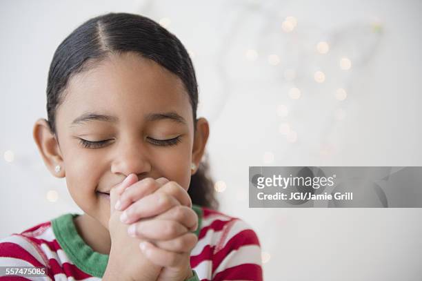close up of mixed race girl praying at christmas - children praying stock pictures, royalty-free photos & images