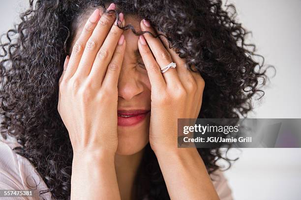 mixed race woman with curly hair covering her face - awkward bildbanksfoton och bilder